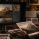 Eine Person vergleicht ein gedrucktes Landschaftsfoto mit seiner digitalen Version auf einem Computermonitor, umgeben von Farbkarten und Bildbearbeitungswerkzeugen - eine ideale Szene für alle, die Bildbearbeitung lernen möchten, in einem warmen, sanft beleuchteten Raum.
