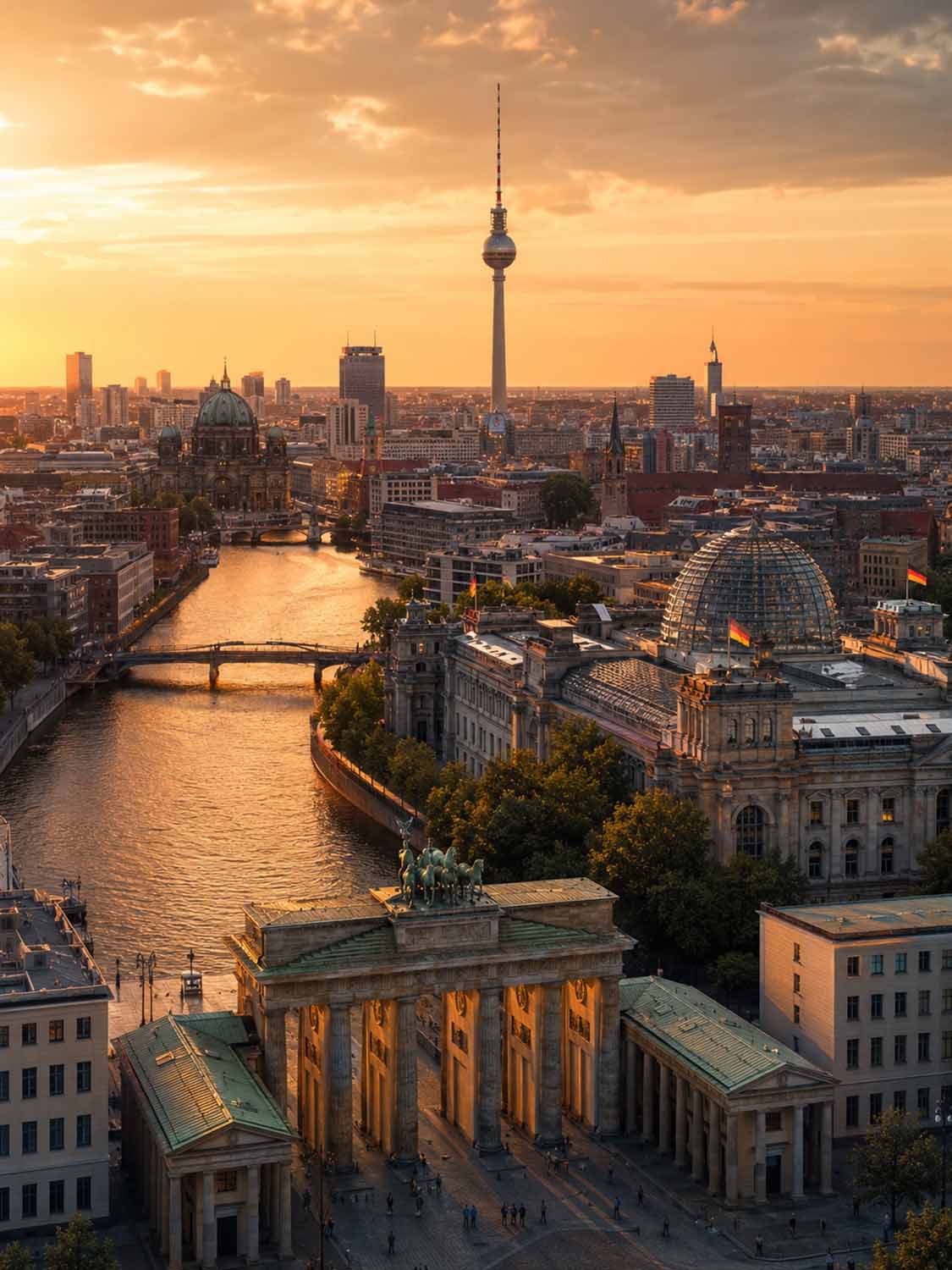 Luftaufnahme von Berlin bei Sonnenuntergang mit dem Brandenburger Tor, der Spree, dem Berliner Dom, dem Reichstag und dem Fernsehturm unter einem goldenen Himmel - die perfekte Inspiration für einen Bildbearbeitung Workshop Berlin.